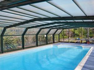 a swimming pool with a glass ceiling and a large swimming pool at Briar Cottage - E5335 in Redisham