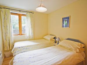 twee bedden in een kleine kamer met een raam bij Briar Cottage - E5335 in Redisham