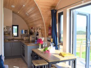 a kitchen with a table and a large window at The Den - Uk32365 in Ellingham