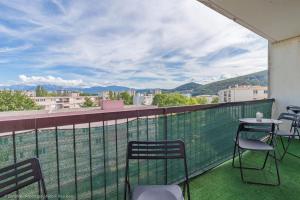 a balcony with chairs and tables and a view of a city at Place privée/Le Marbré/Moderne/60m2 in Annemasse