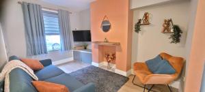 sala de estar con sofá azul y 2 sillas en Sutherland St - 2 bed home with free Parking en York