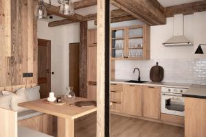 a kitchen with wooden cabinets and a wooden table at Apartament Malinowa in Zakopane