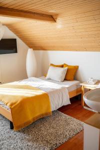 a bedroom with a large bed and a sink at Gästehaus Aemisegg in Sankt Peterzell