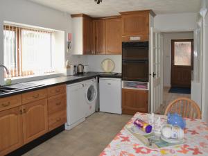 a kitchen with wooden cabinets and a table with a plate on it at Smugglers Lookout in Mundesley