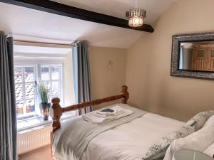 um quarto com uma cama e uma janela em Forge View Cottage em Thornton Dale