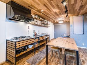 a kitchen with a wooden table and a counter top at Rakuten STAY HOUSE x WILL STYLE Matsue 102 in Matsue