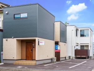a building with a black roof on a parking lot at Rakuten STAY HOUSE x WILL STYLE Matsue 102 in Matsue