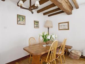 a dining room with a wooden table and chairs at Shaws Cottage in Thornton Dale