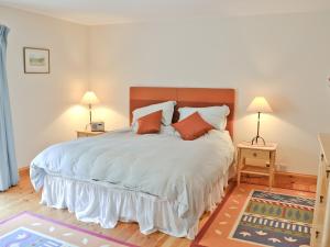 1 dormitorio con 1 cama grande y 2 mesitas de noche en Till Cottage, en Milfield