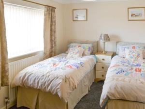 two twin beds in a bedroom with a window at Seashore Hideaway in Newbiggin-by-the-Sea