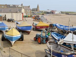 a bunch of boats are parked on the beach at Seashore Hideaway in Newbiggin-by-the-Sea