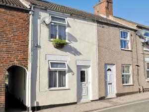 a brick house with a white door and a window at Amberley Cottage in Alfreton