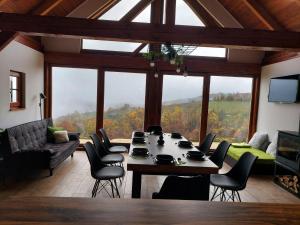 ein Wohnzimmer mit einem Tisch und Stühlen sowie einem großen Fenster in der Unterkunft Hiška oddiha - Rest house in Sromlje