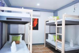a room with two bunk beds and a room with at WOZA INN BORACAY in Boracay