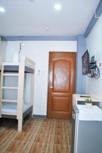 Zimmer mit einem Etagenbett und einer Holztür in der Unterkunft WOZA INN BORACAY in Boracay