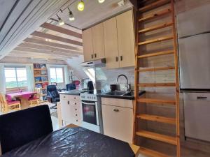 a kitchen in a tiny house with a staircase at Topfloor Apartment Separate Entranc Nice view Stord in Fitjar
