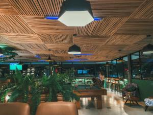 a restaurant with a wooden ceiling and tables and chairs at Selina Baños in Baños