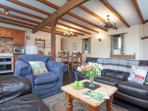 a living room with blue couches and a table at The Roundhouse - Tbe in Crackington Haven