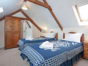 a bedroom with two beds with towels on them at The Roundhouse - Tbe in Crackington Haven