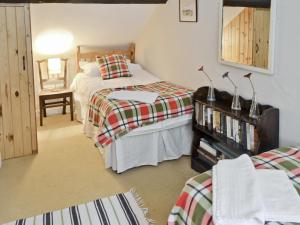 a bedroom with two beds and a mirror at Graig in Beaumaris