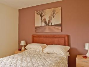 a bedroom with a bed and a painting on the wall at Flowerdale Cottage in Lochgoilhead