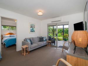 un soggiorno con divano e letto di 12 on Hilldale - Kuaotunu Holiday Unit a Whitianga