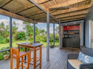 een terras met een tafel en stoelen bij 12 on Hilldale - Kuaotunu Holiday Unit in Whitianga