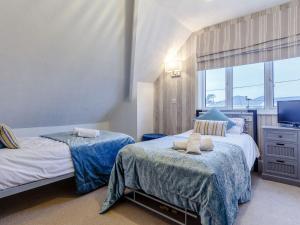 a bedroom with two beds and a television at Beau Rivage in Goodrington