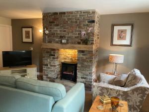 a living room with a fireplace and a blue couch at Little Fox Cottage in Levisham