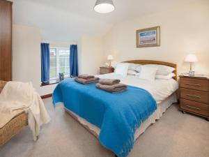 um quarto com uma cama grande com cobertor azul em Seascape em Craster