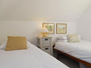 sypialnia z 2 łóżkami i lampką na stole w obiekcie Bellagio w mieście Padstow