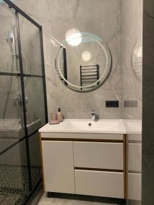 a bathroom with a sink and a mirror at «Перлина Умані» апартаменти in Umanʼ