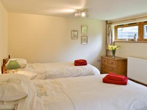 a bedroom with two beds and a window at Butlers Barn in Darsham