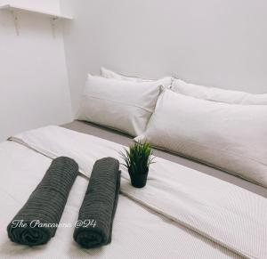 ein Bett mit zwei Kissen und einer Topfpflanze darauf in der Unterkunft The Pancarona24 Homestay forMuslim in Ipoh