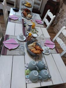 een tafel met een ontbijt van brood en croissants bij Lazy Days in Rancon