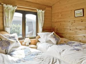 two beds in a room with a window at Skiddaw Lodge in Keswick