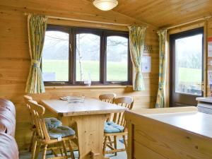a dining room with a wooden table and chairs at Skiddaw Lodge in Keswick