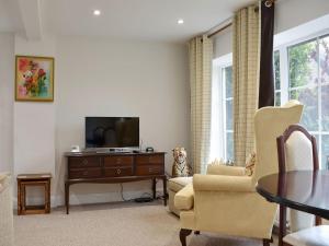 a living room with a tv and two chairs and a table at Perrys in Lyminster