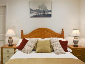 a bedroom with a bed with pillows and two lamps at Perrys in Lyminster