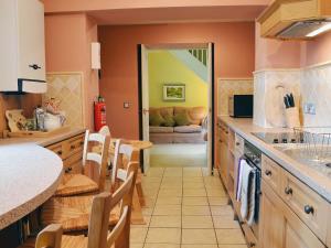 Uldale的住宿－老馬厩度假屋，厨房设有橙色墙壁和台面