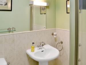Uldale的住宿－老馬厩度假屋，一间带水槽和镜子的浴室