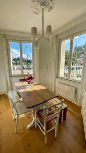 a dining room with a table and chairs and windows at Port de Pornic. Vue mer. Sea view. 4 rooms. in Pornic