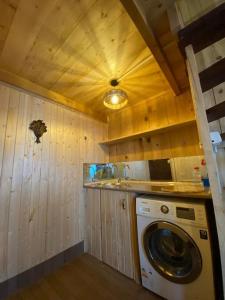 una lavadora y secadora en una cocina con paredes de madera en Woodland house, en Dzentsmani