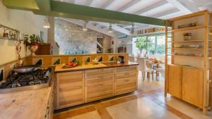 une grande cuisine avec des placards en bois et une cuisinière dans l'établissement Casale Palombieri 12, Emma Villas, à Modica