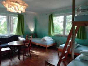 a room with a bunk bed and a table and chairs at Peanuts Hostel & Meer in Surendorf