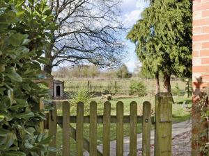a wooden fence with a field behind it at Beech Cottage in Kirkby on Bain