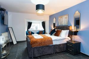 a bedroom with a large bed and a blue wall at The Ancient Unicorn in Barnard Castle