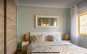 a bedroom with a bed with a mirror on the wall at Eine Wohnung für den perfekten Urlaub !!! in Quarteira