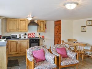 a kitchen with two chairs and a table at Grooms Cottage in Elsdon