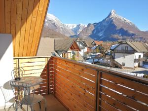 a balcony with a table and chairs and mountains at Hostel Soča Rocks in Bovec